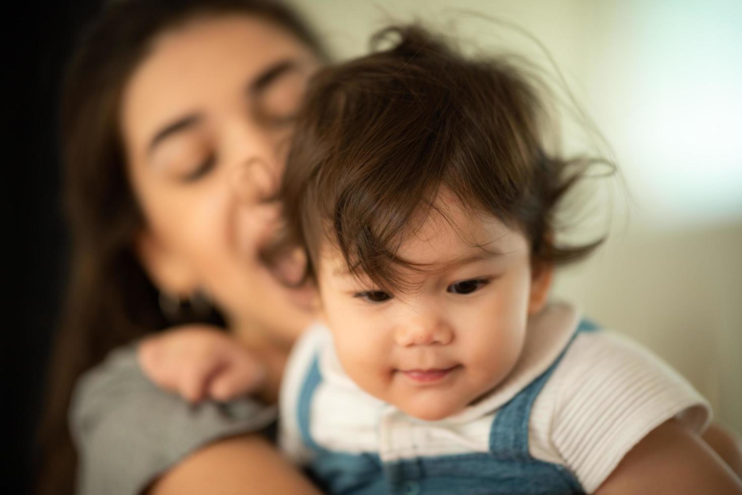 jovem mãe e filho bebê estão felizes em casa, conceito de família de infância com mãe caucasiana e garotinho, estilo de vida de cuidados com recém-nascidos foto