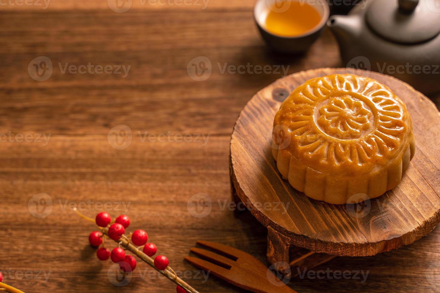 bolo de lua configuração de mesa de bolo de lua - pastelaria tradicional chinesa em forma redonda com xícaras de chá em fundo de madeira, conceito de festival de meio-outono, close-up. foto
