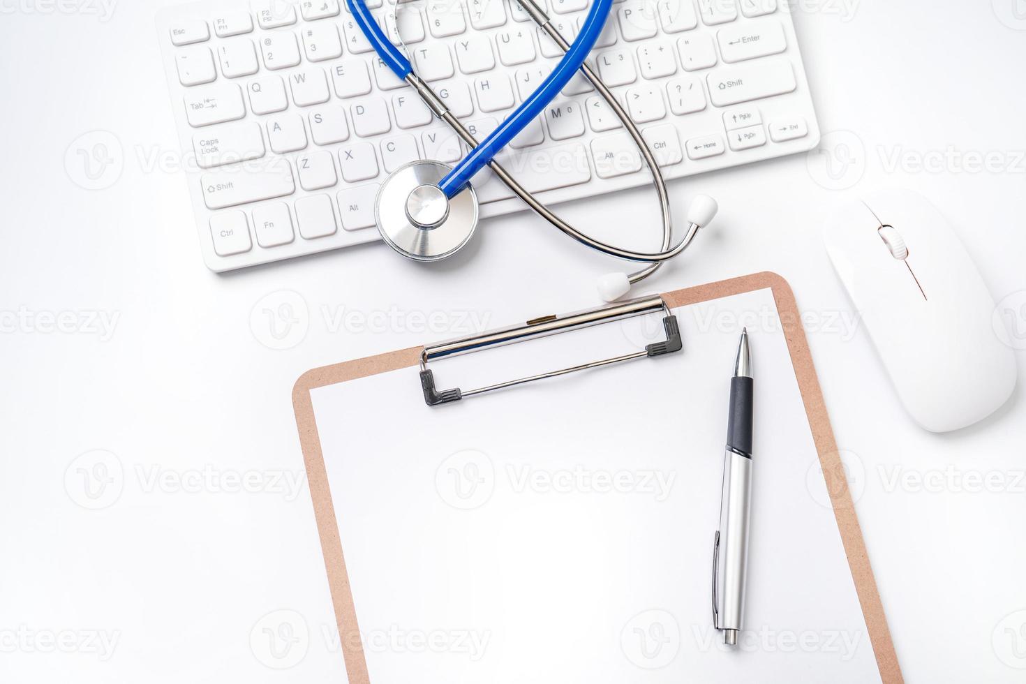 conceito médico - estetoscópio no teclado do computador em fundo branco. conceito de tratamento de cuidados de longo prazo médico. vista superior, configuração plana, espaço de cópia foto