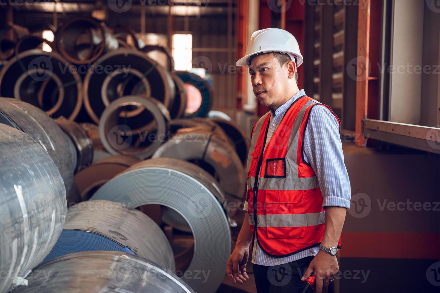 operário trabalhando no local de trabalho industrial, usando capacete para segurança foto