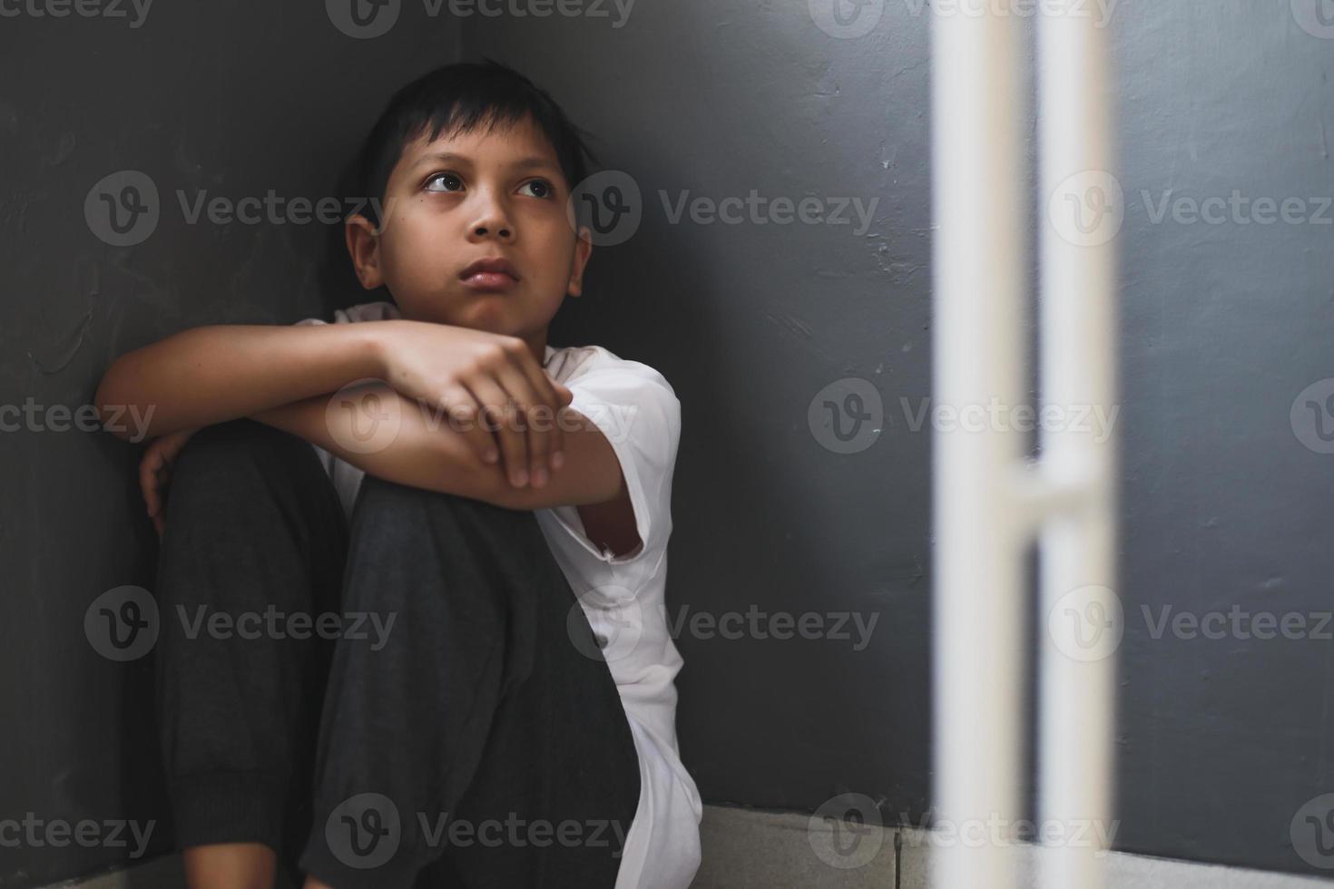 menino solitário triste e sentado sozinho em casa foto