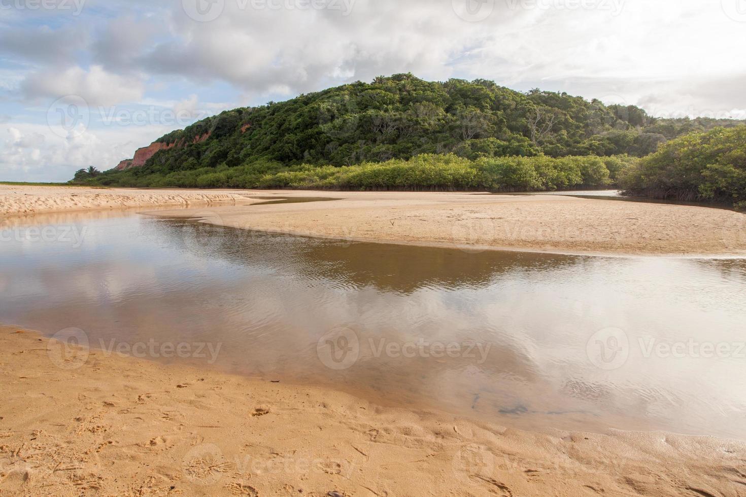 rio que deságua na praia de taipe perto de arraial d ajuda, bahia, brasil foto