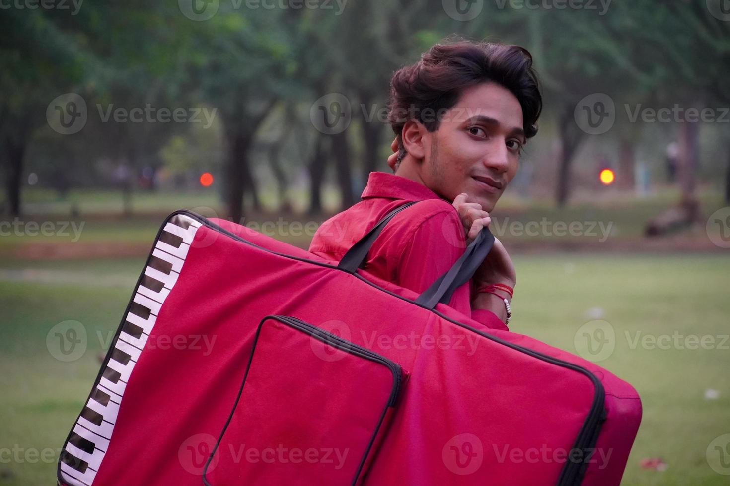 menino sorrindo imagem com bolsa de piano foto