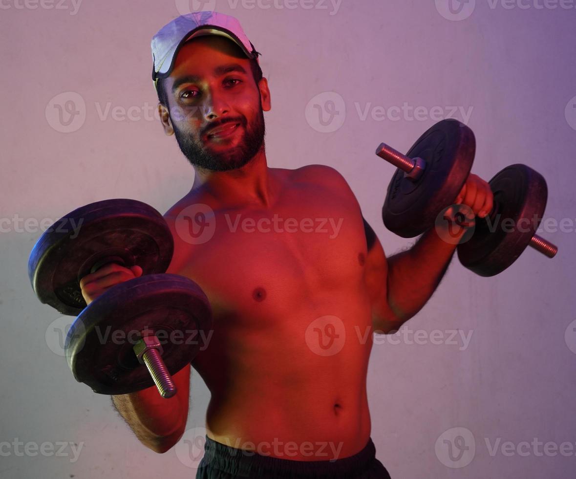 homem levantando pesos em luz neon foto