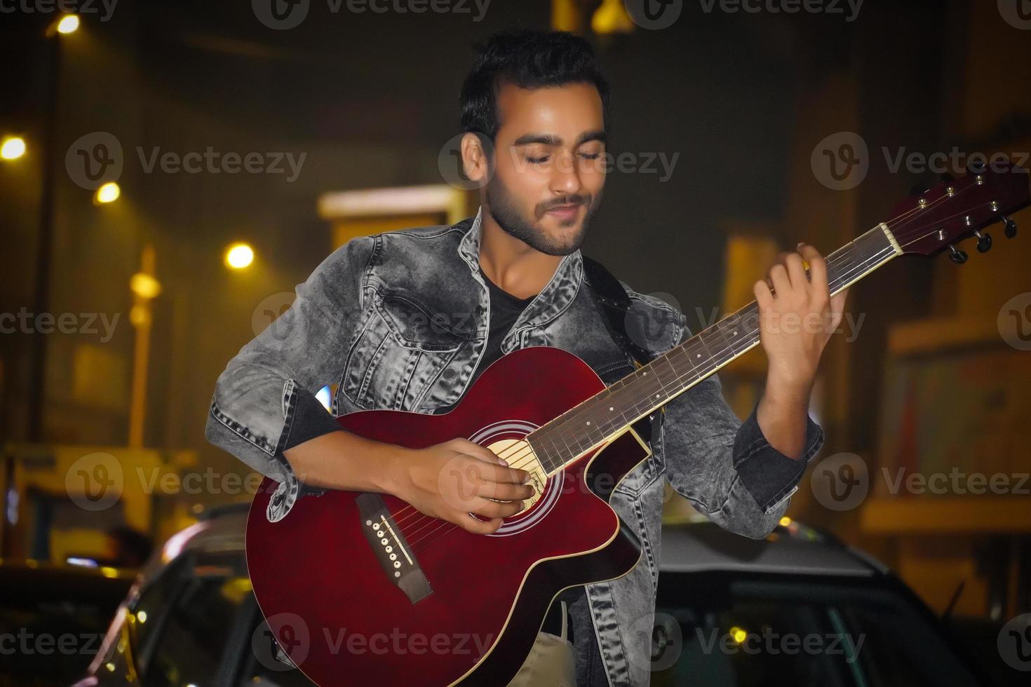 homem com guitarra vermelha e tocando sua guitarra foto