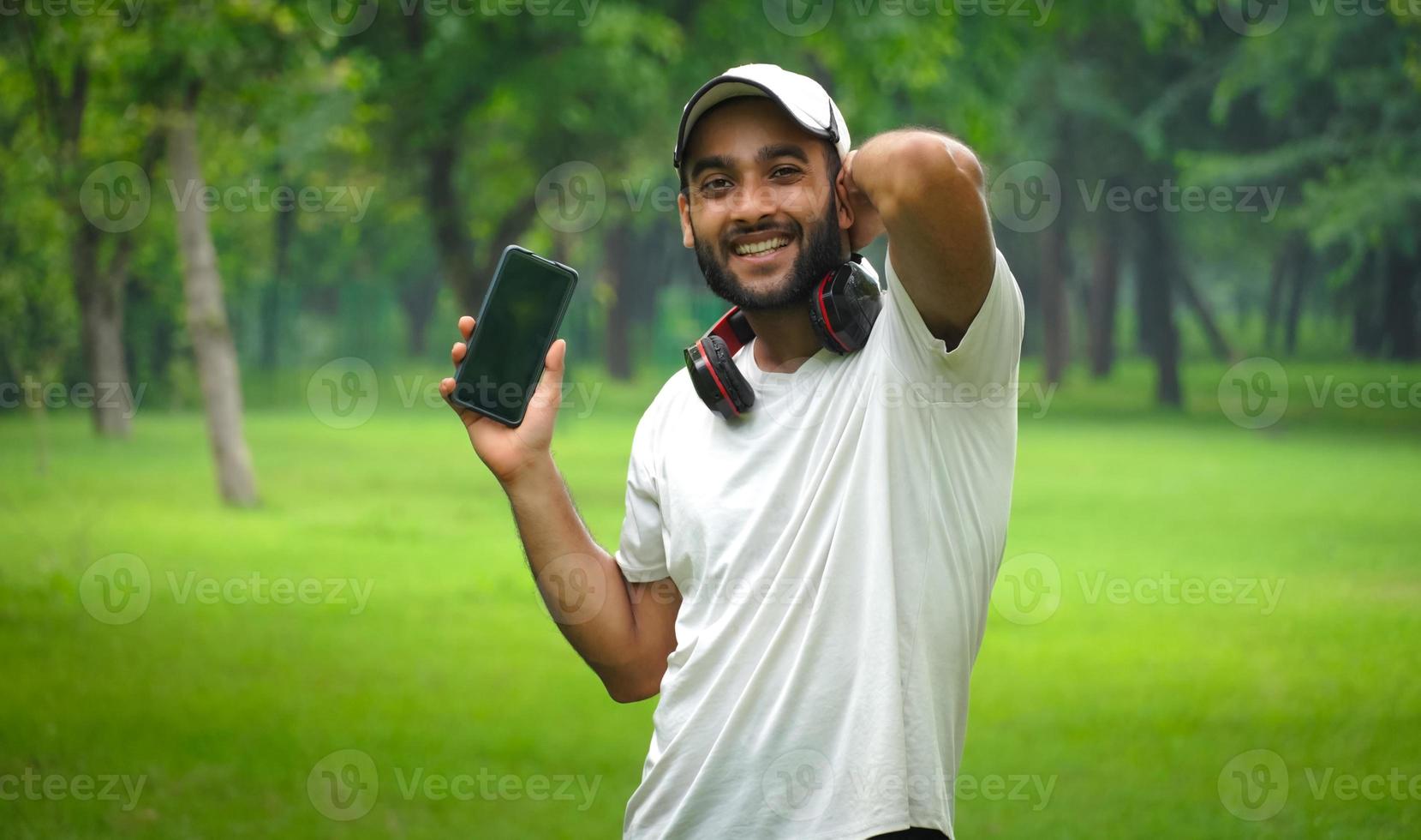homem com celular e fone de ouvido feliz foto