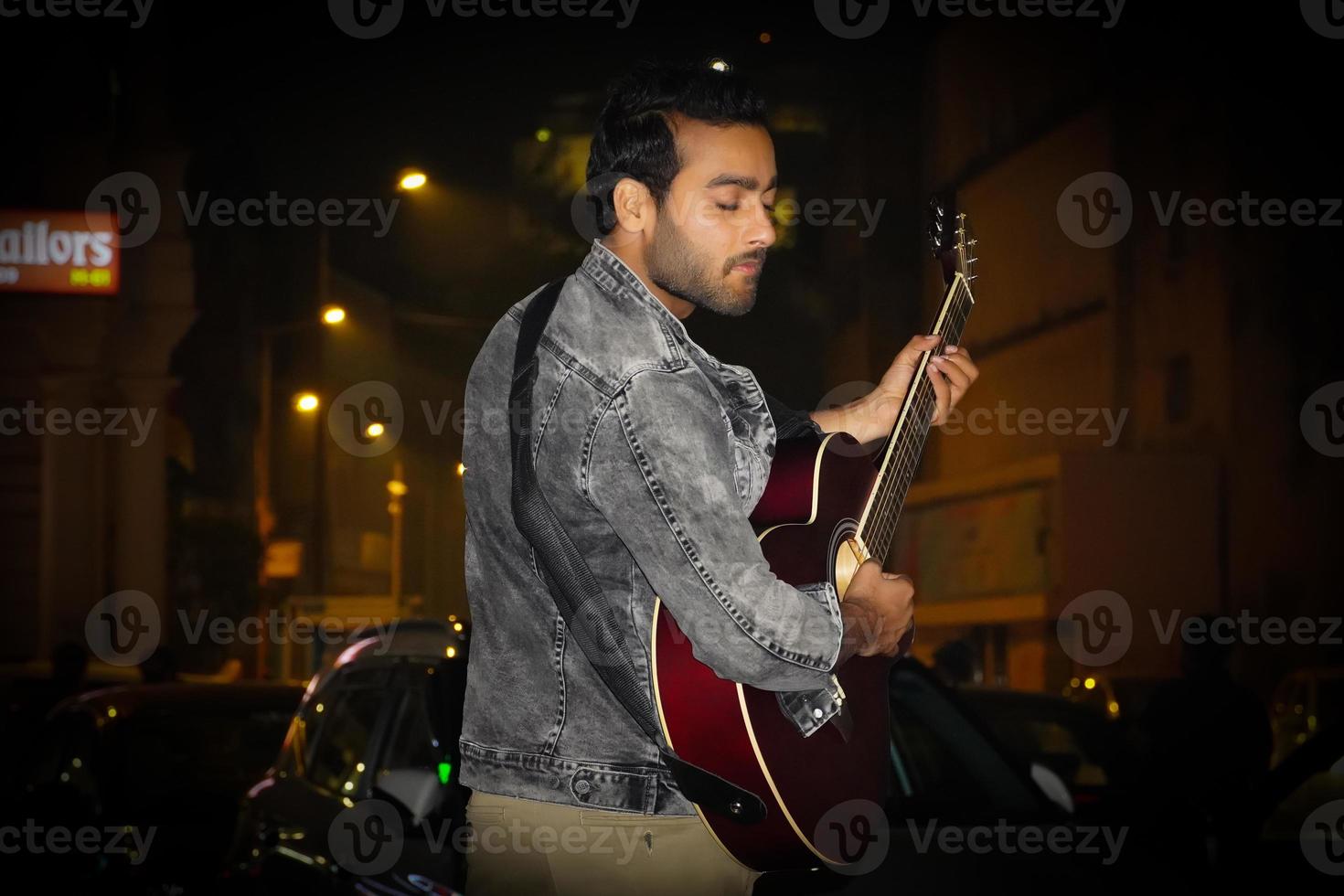 um guitarrista tocando sua guitarra na noite foto