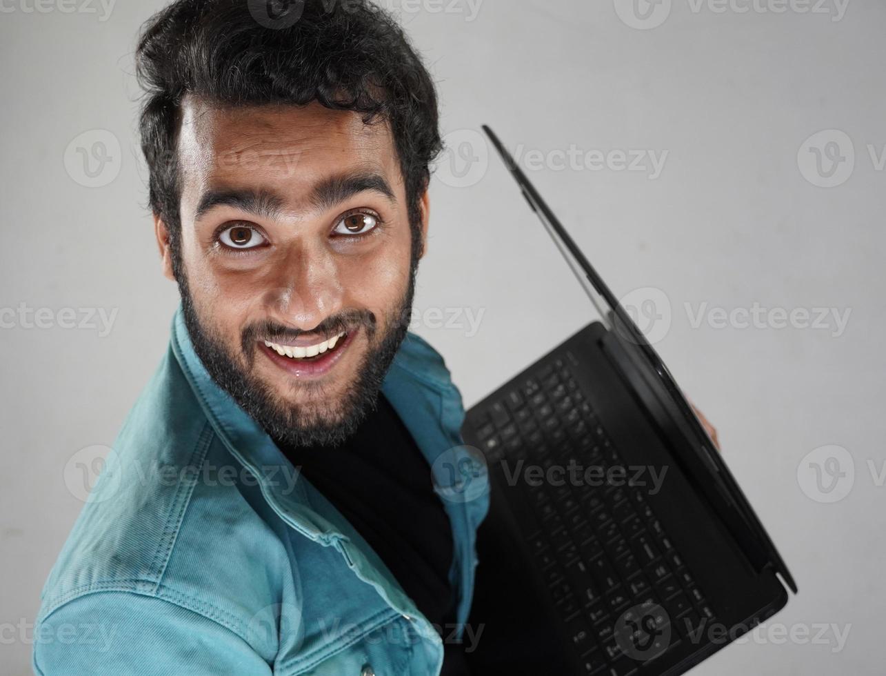 imagem de um estudante com laptop feliz assistindo a câmera e sorrindo foto