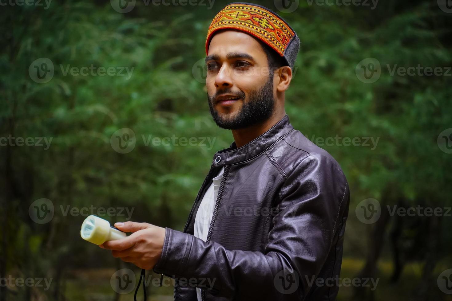 menino de Himachali de retrato na floresta com tocha no Himalaia foto