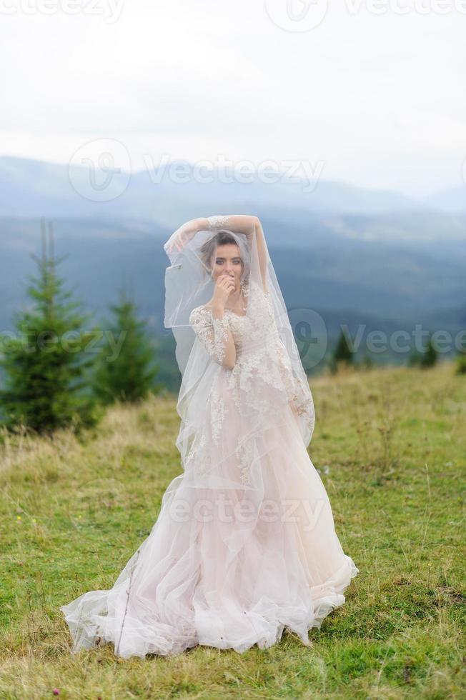 a noiva em um vestido rosa e arejado roda e brinca com seu vestido. foto