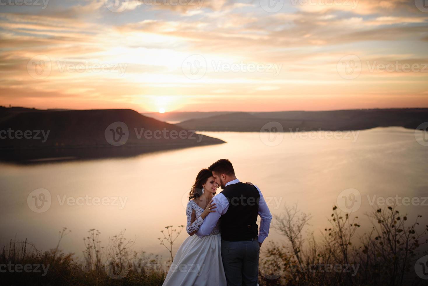 a noiva e o noivo estão andando perto do antigo castelo. o casal fica de costas um para o outro. foto