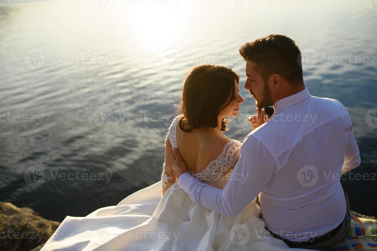 a noiva e o noivo estão andando perto do antigo castelo. o casal fica de costas um para o outro. foto