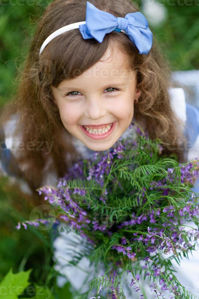 retrato de uma menina bonita vestida de alice. sessão de fotos estilizada na natureza.