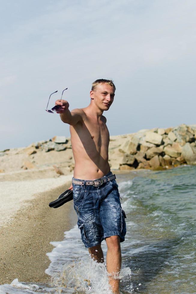 um homem caminhando à beira-mar foto