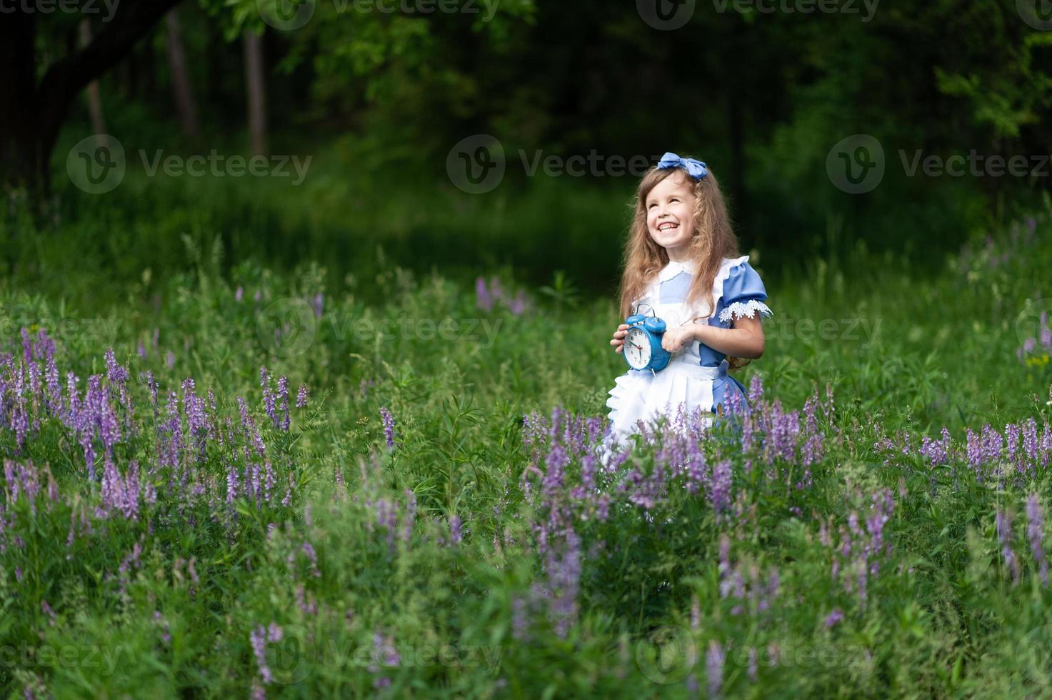 menina bonita em uma fantasia de alice detém um velho relógio antigo. foto