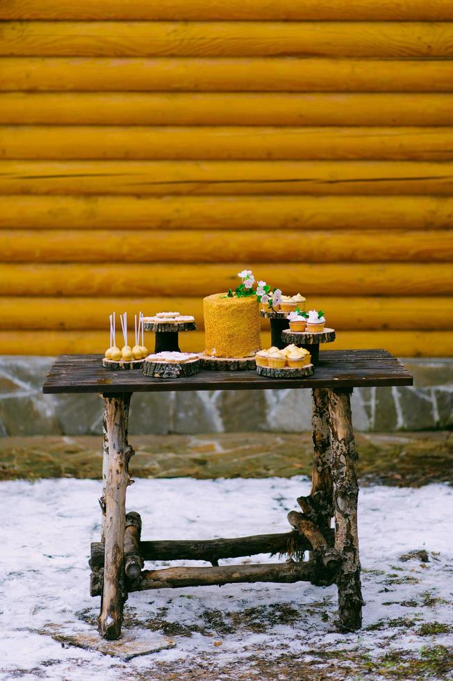 bolos em uma mesa de madeira para uma barra de chocolate de casamento foto