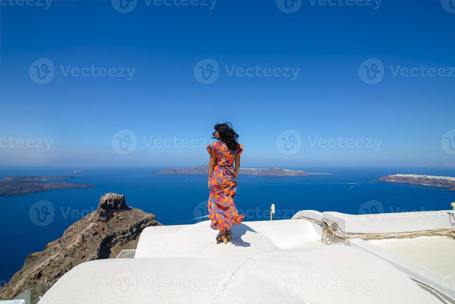 um homem e uma mulher estão se abraçando contra o pano de fundo do rock skaros na ilha de santorini. a aldeia de Imerovigli. foto