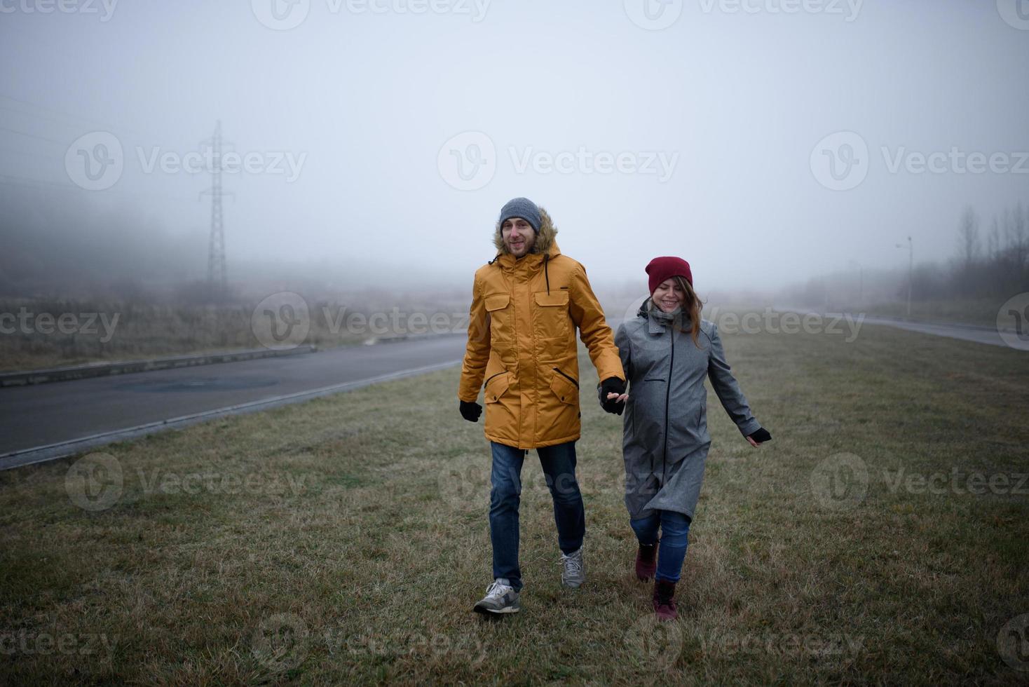 casal grávido amoroso está andando fora da cidade no final do outono. foto