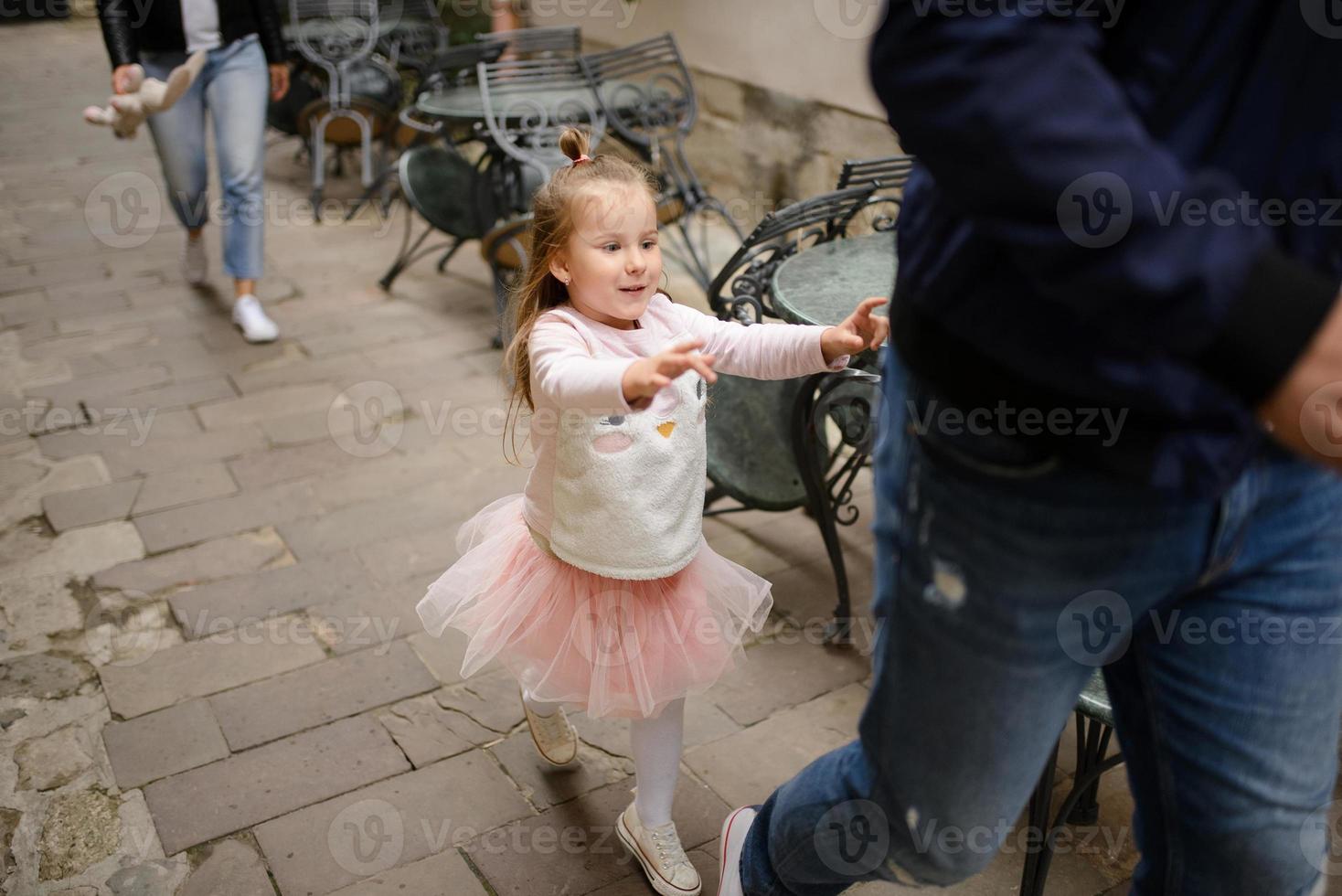 pais e sua filha estão sentados nos degraus de uma antiga igreja. foto