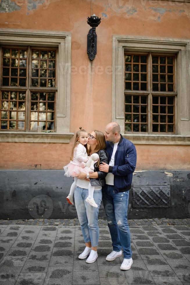 pais e sua filha estão sentados nos degraus de uma antiga igreja. foto