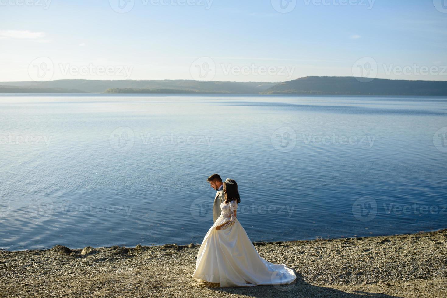 a noiva e o noivo estão andando perto do antigo castelo. o casal fica de costas um para o outro. foto