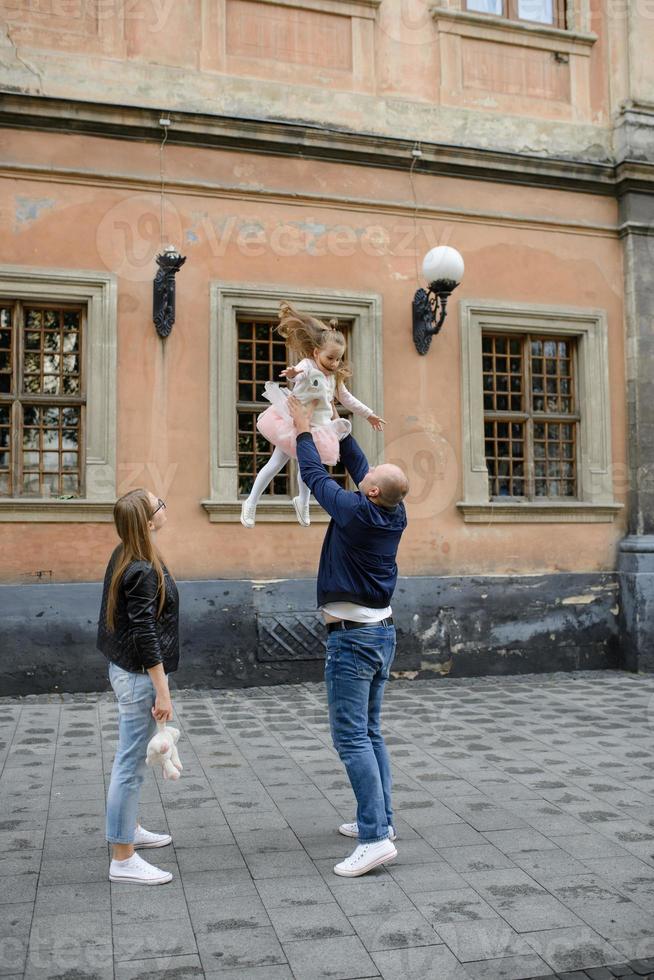 pais e sua filha estão sentados nos degraus de uma antiga igreja. foto