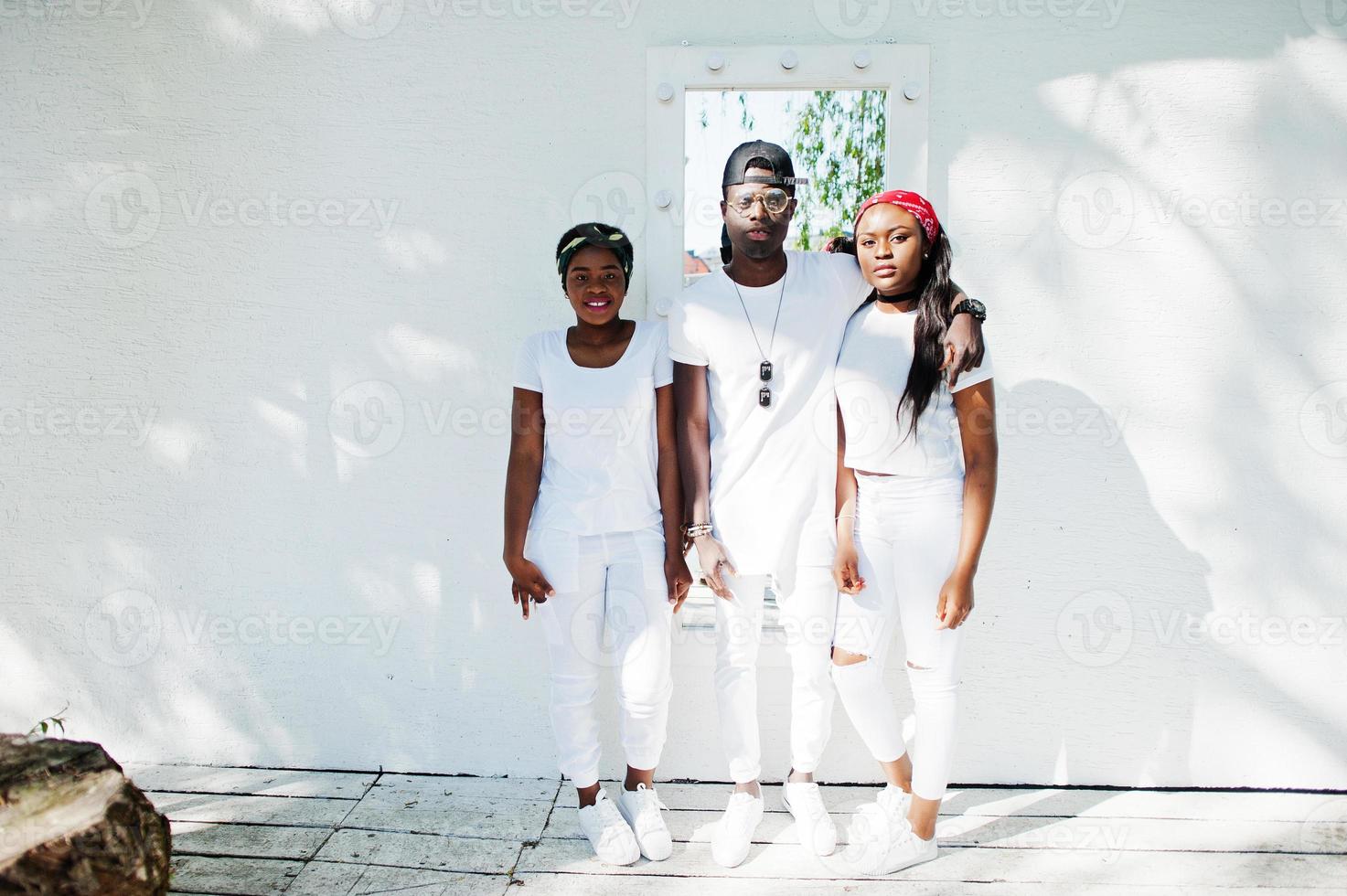 três elegantes amigos afro-americanos, usam roupas brancas contra dois  carros de luxo. moda de rua de jovens negros. homem negro com duas garotas  africanas. 6933626 Foto de stock no Vecteezy