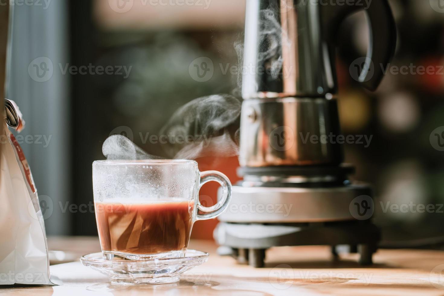 xícara de café com fundo de cafeteira moka vintage na mesa de madeira no escritório em casa foto