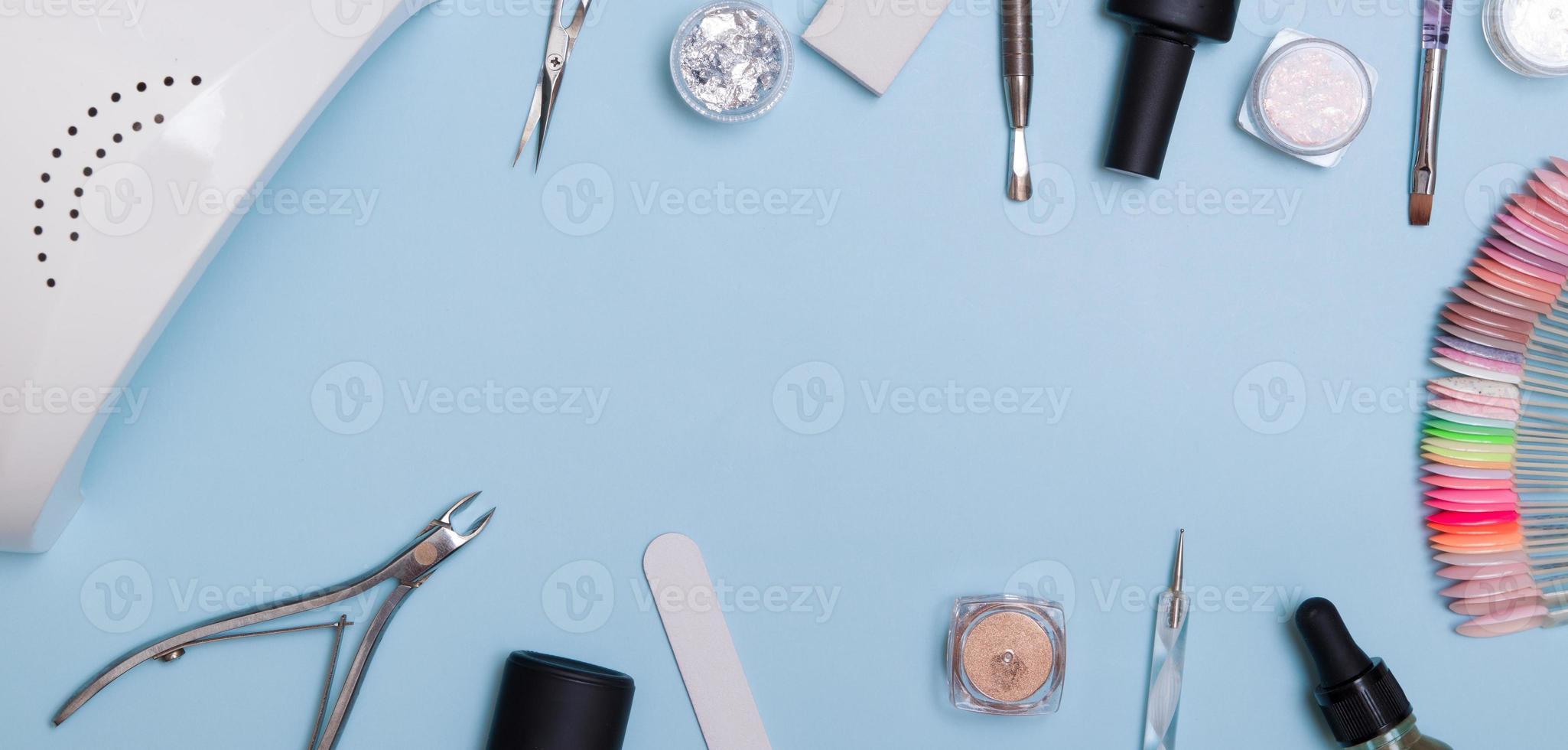 ferramentas e materiais para manicure plana lay com espaço de cópia em formato de banner. knolling em um fundo azul foto