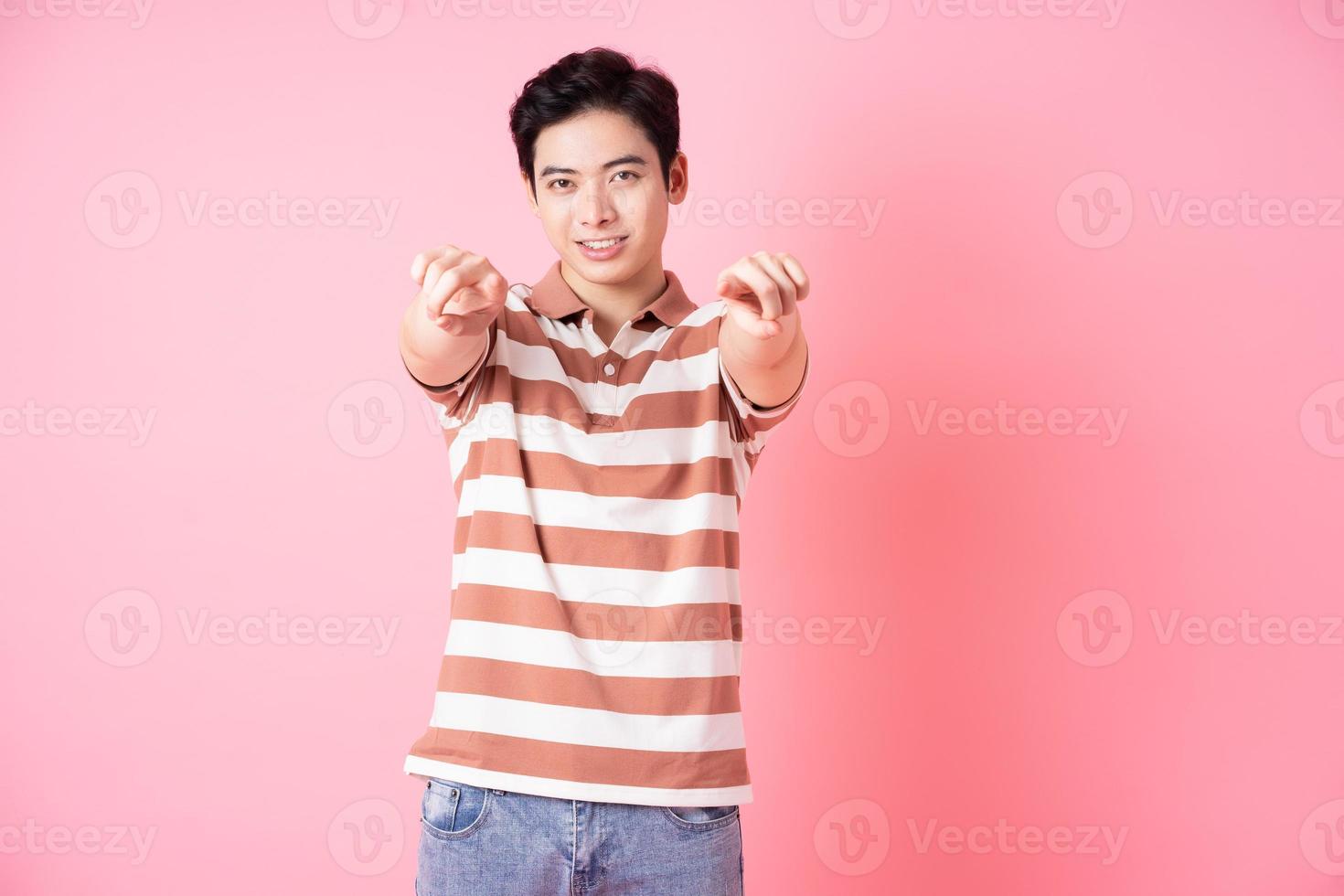 jovem asiático posando em fundo rosa foto