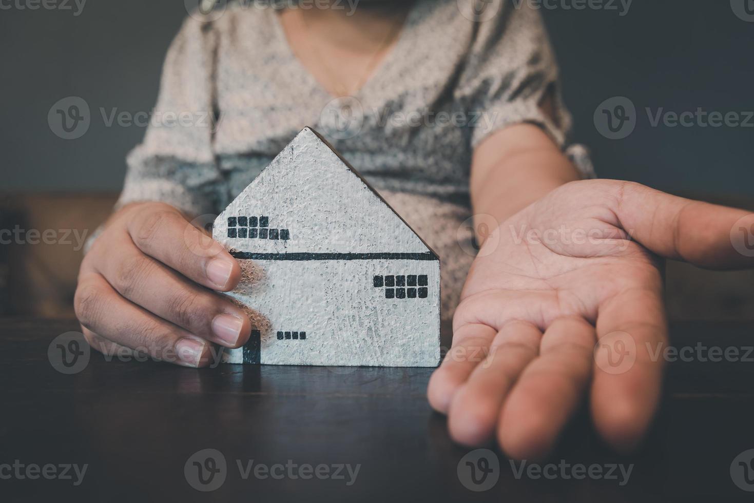 empréstimo à habitação e conceito de agência de venda de corretor de imóveis. mãos de mulher de negócios oferecem modelo de casa ao cliente para venda, aluguel. agente imobiliário de casa de negócios e investimento residencial. foto