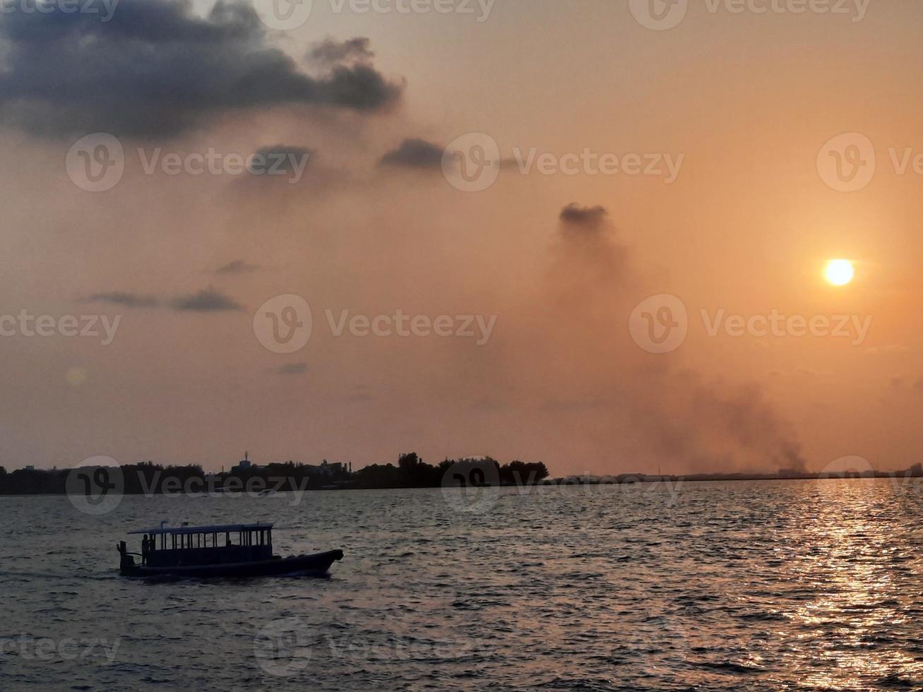 belo pôr do sol na praia masculina, maldivas foto