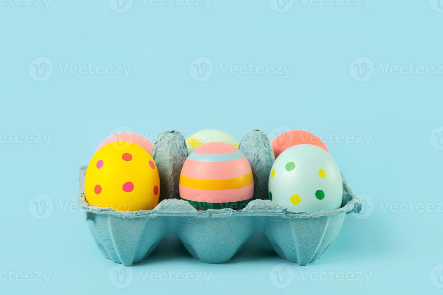 Feliz Páscoa. ovos de páscoa pintados em uma caixa de papelão azul aberta foto