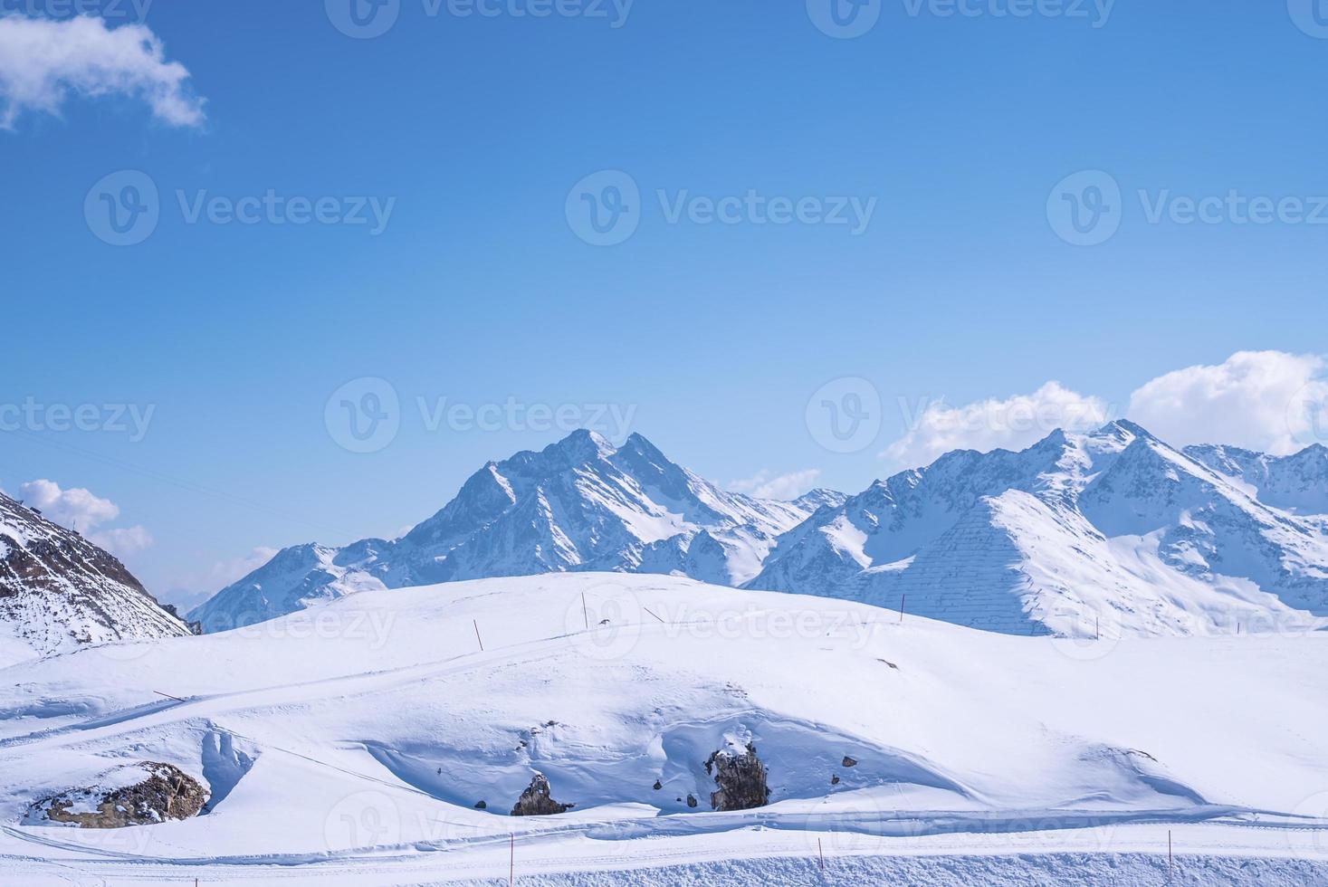 faixas na encosta da paisagem coberta de neve contra o céu azul foto