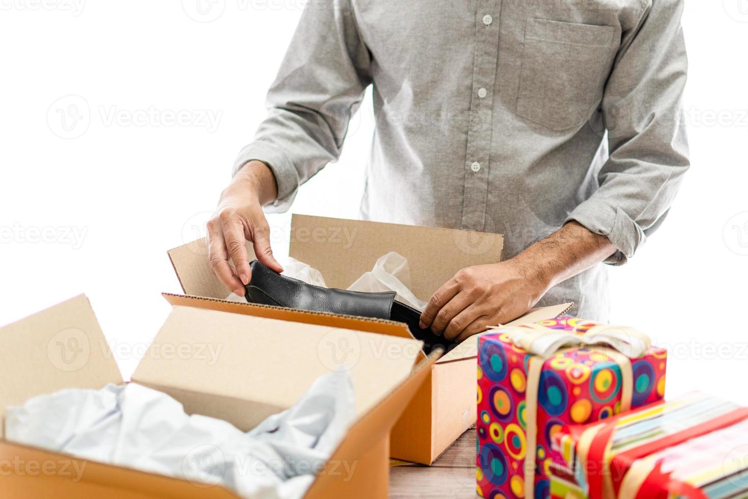 homem unboxing e compras online. ele compra sapatos online. o conceito para desembalar, presente, feliz, entregar, abrir, desfrutar, animado, embalagem, ano novo, natal, aniversário, foco seletivo. fundo branco foto