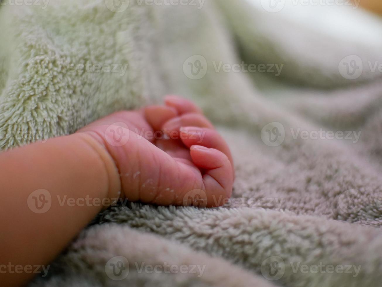 mão de bebê no cobertor cinza. recém-nascidos se sentem seguros e aquecidos. foco suave seletivo. foto