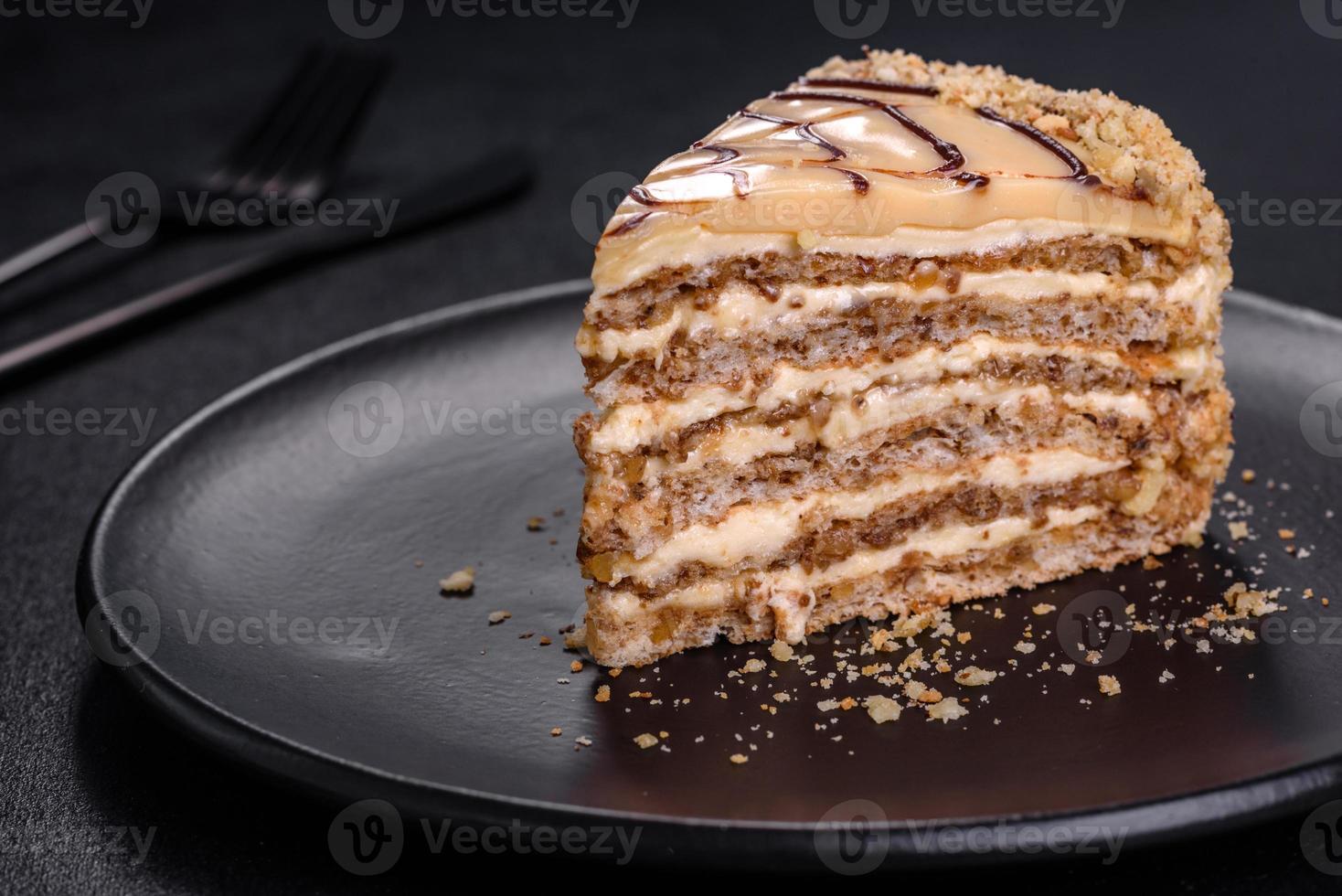 bolo esterhazy fatiado em close-up de chapa preta. sobremesa doce de delicatessen com massa de merengue de amêndoa e creme de manteiga foto