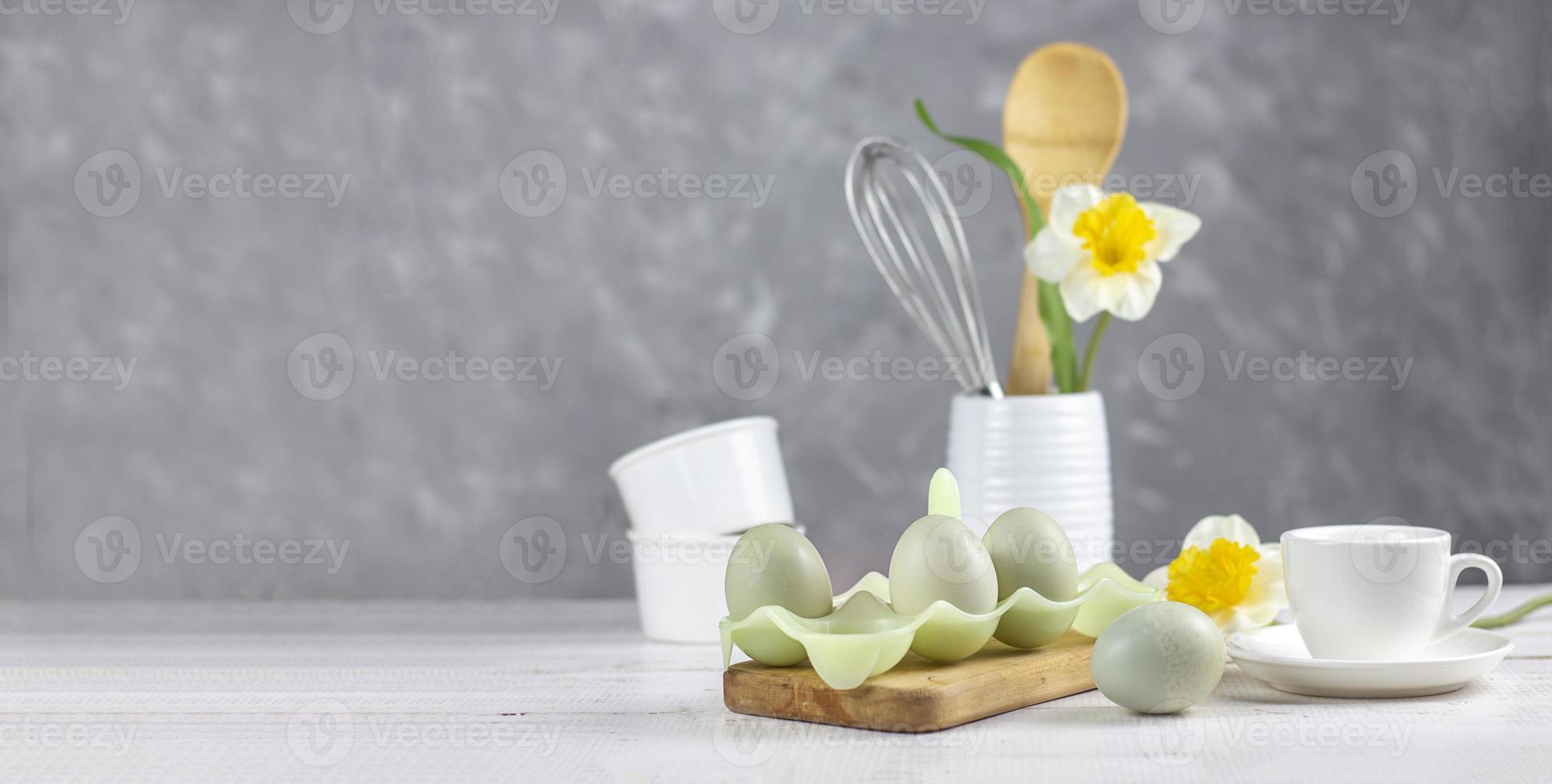 utensílios de cozinha. fundo de páscoa. páscoa. flores e ovos. bandeira. espaço de cópia foto