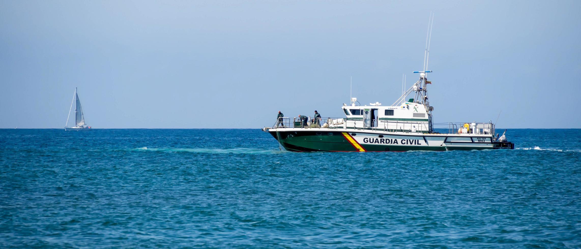 calahonda, andaluzia, espanha, 2014. guardia barco civil usando redes para tentar recuperar algo foto