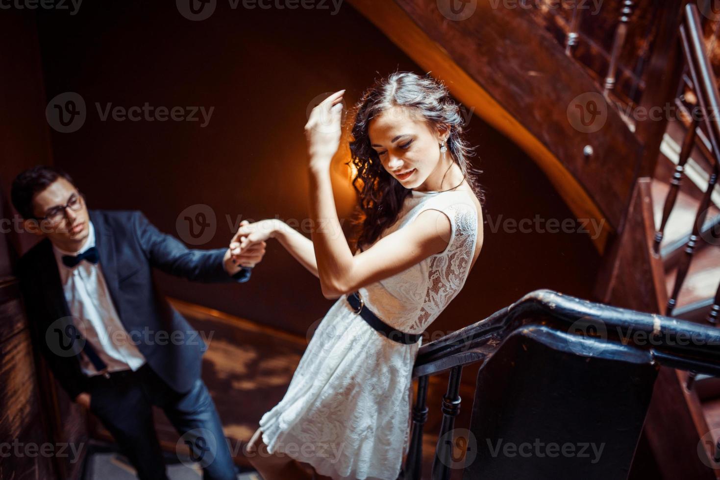 moda jovem casal dançando na escada e abraçando uns aos outros foto