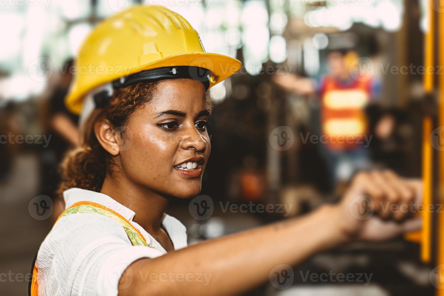 trabalhadora adolescente de mulheres negras americanas trabalhando na fábrica da indústria com máquina de aço pesado. foto