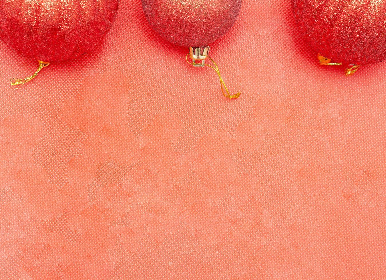 fundo de natal.três bolas vermelhas de natal em fundo vermelho foto