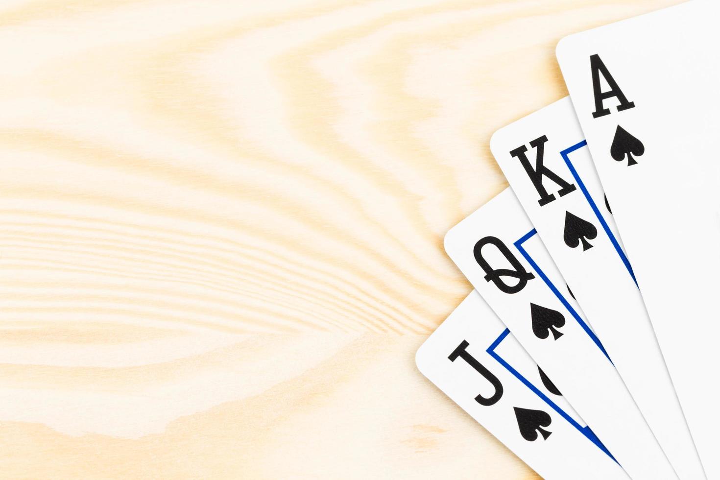 cartas de jogar pôquer royal flush em fundo de madeira foto