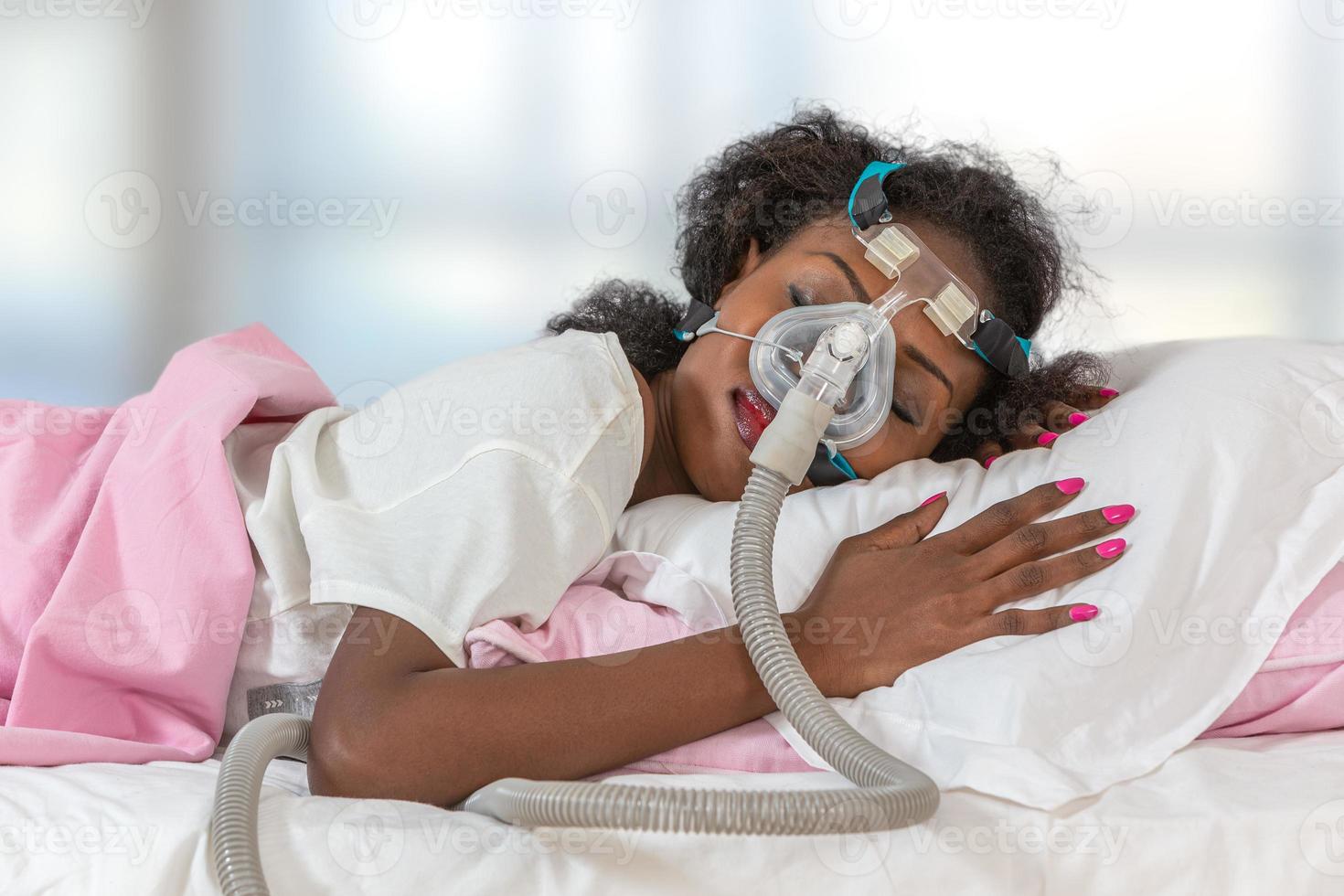 mulher usando capacete cpap para dormir contra apnéia foto