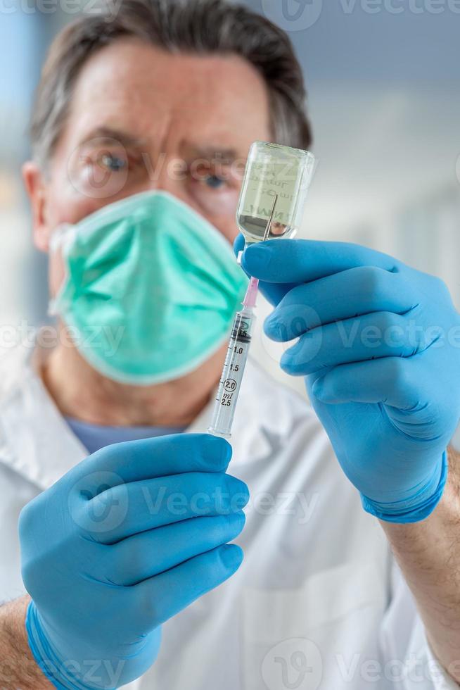 o médico enche uma seringa com vacina em fundo desfocado. foto