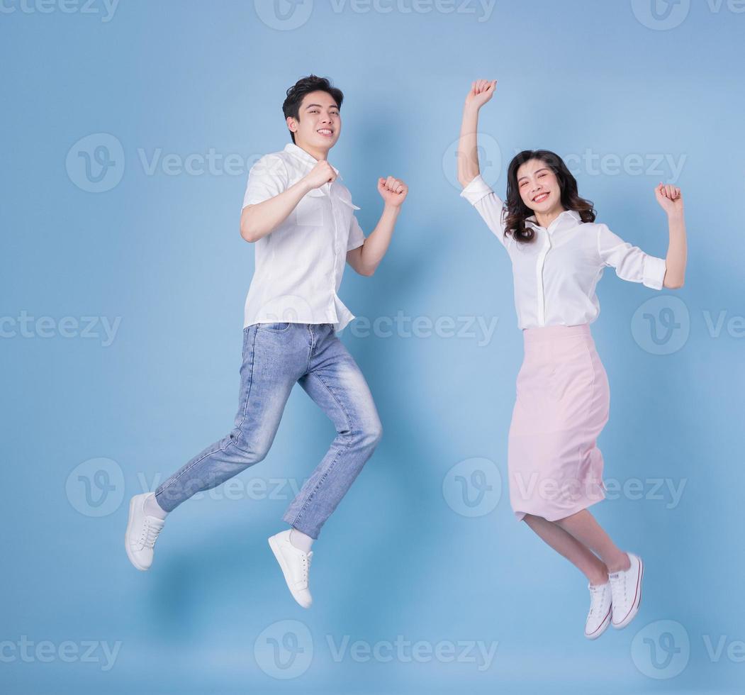 imagem de corpo inteiro do jovem casal asiático sobre fundo azul foto