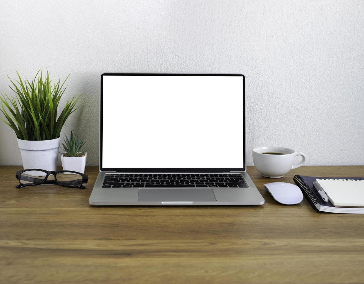 mesa de escritório de madeira com teclado de laptop, xícara de café e notebook, computador mouse com material de escritório de equipamentos. conceito de negócios e finanças. local de trabalho, postura plana com espaço de cópia em branco. foto