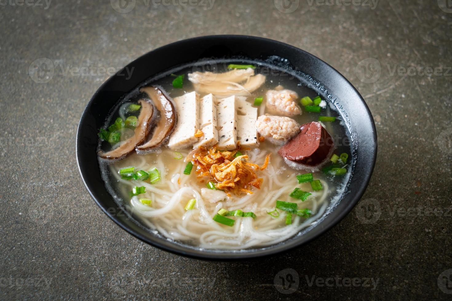 sopa de macarrão de arroz vietnamita com linguiça vietnamita, legumes servidos e cebola crocante foto