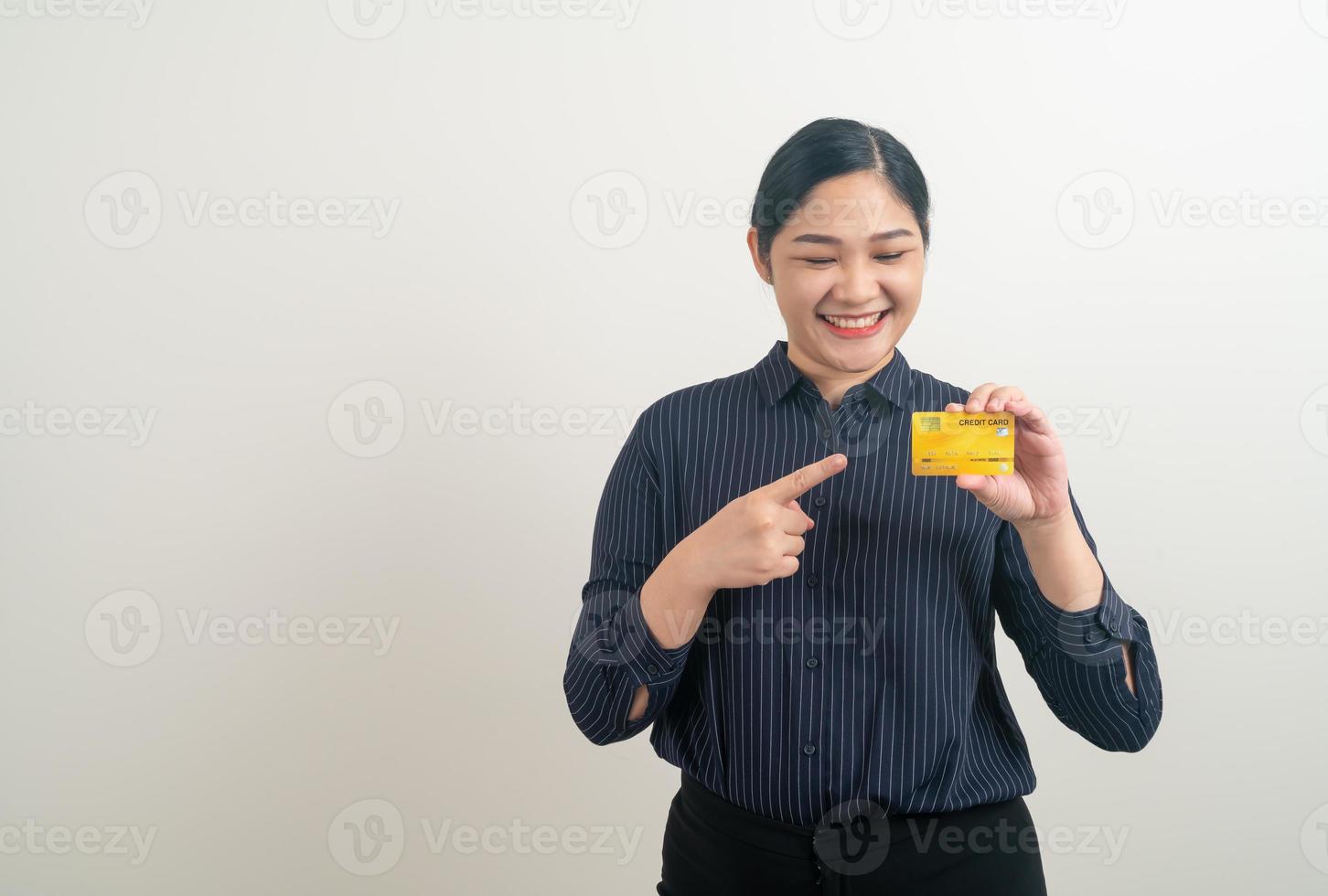 mulher asiática segurando um cartão de crédito com fundo branco foto