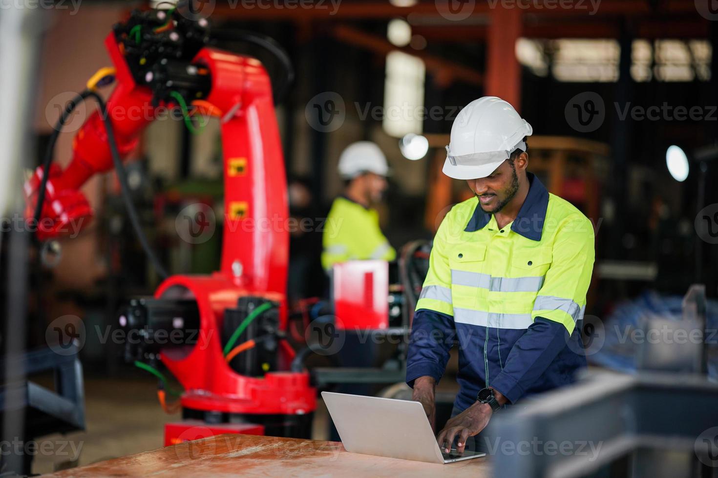 funcionário de fábrica industrial trabalhando com peça de máquina, verificando e testando equipamentos industriais e braços robóticos em grande fábrica de plantas de fabricação de fios e cabos eletrônicos elétricos foto